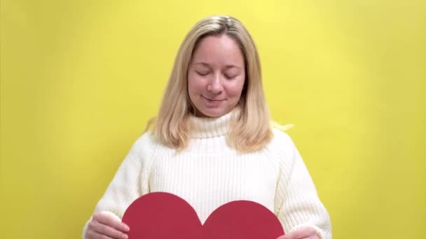 Happy Young smiling woman with a paper heart in her hands — Stock Video