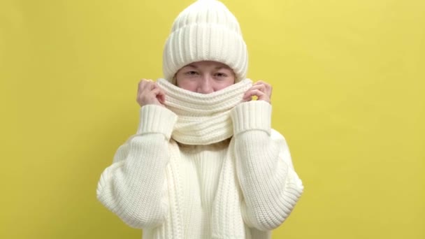 4k. Mujer sonriente joven con suéter de punto blanco, bufanda y sombrero — Vídeos de Stock
