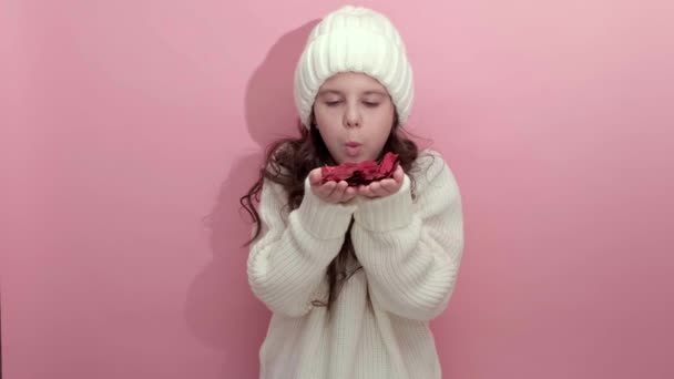 Girl blowing red paper confetti in shape of heart out of her hands — Stock Video