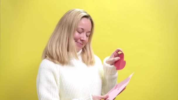 Heureuses jeunes femmes obtiennent enveloppe rose avec coeur en papier rose — Video