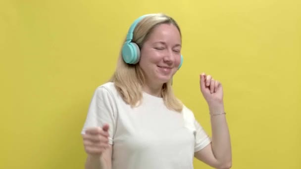 Mulher bonita em uma camiseta branca ouvir música em fones de ouvido — Vídeo de Stock