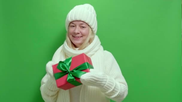 Ung leende kvinna i vit stickad tröja med presentförpackning — Stockvideo