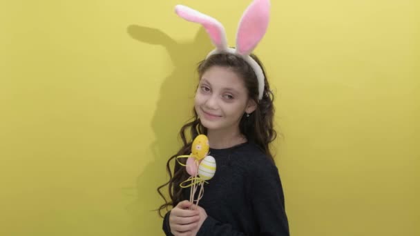 Gelukkig Pasen. Goed uitziende lachende meisje kind met konijn pluizige oren — Stockvideo