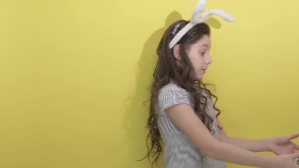 かわいいです女の子とともにウサギ耳見ます彼女の卵カートンのカラフルなイースターの卵 — ストック動画