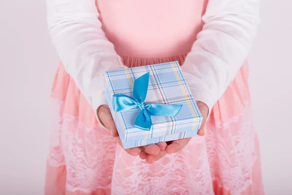 Liten flicka med en gåva i handen — Stockfoto
