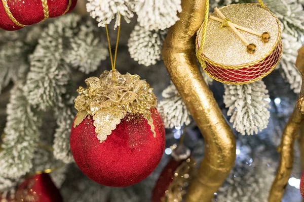 Κοντινό πλάνο των διακοπών τοποθεσία με κόκκινο χρυσό παιχνίδια, γιρλάντες και τύμπανα στο χριστουγεννιάτικο δέντρο — Φωτογραφία Αρχείου