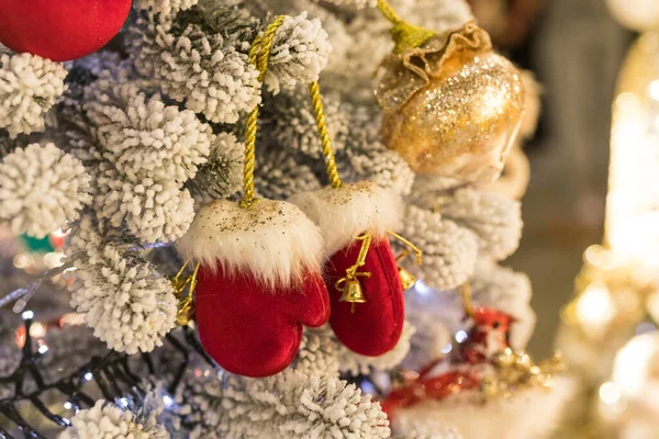 Κοντινό πλάνο της τοποθεσίας διακοπών με κόκκινα χρυσά παιχνίδια, γιρλάντες και γάντια στο χριστουγεννιάτικο δέντρο — Φωτογραφία Αρχείου