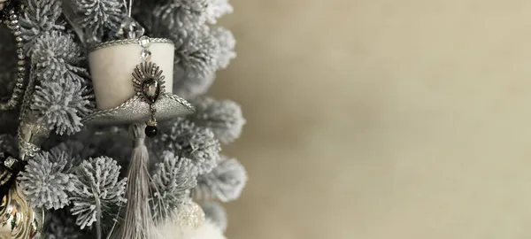 Sluiten van vakantie locatie met speelgoed, bloemenslingers en witte grijze hoed op kerstboom — Stockfoto