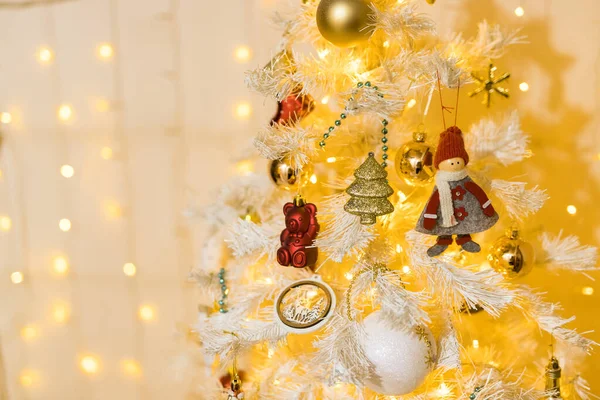Κλείσιμο της τοποθεσίας διακοπών με παιχνίδια και γιρλάντες σε λευκό κίτρινο χριστουγεννιάτικο δέντρο — Φωτογραφία Αρχείου
