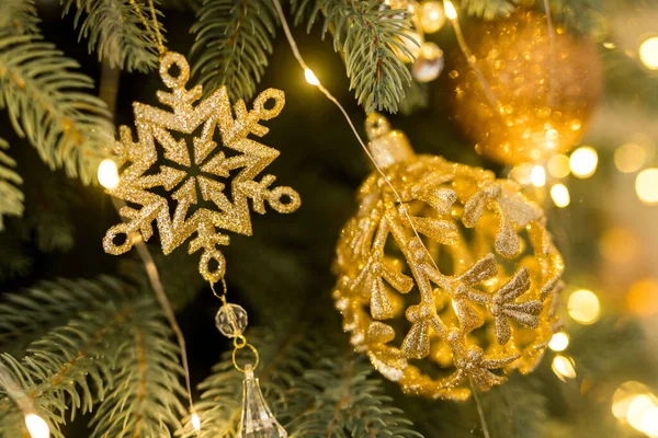 ゴールドボールとスノーフレークのおもちゃと緑のクリスマスツリー上のガーランドで休日の場所の閉鎖 — ストック写真