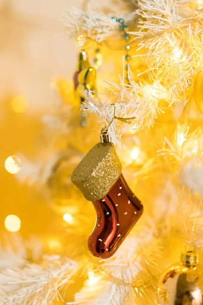 赤い金の靴下のおもちゃと白い黄色のクリスマスツリー上のガーランドで休日の場所の閉鎖 — ストック写真