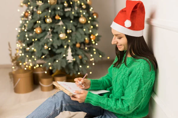 Pohled z boku mladé dívky psaní dopis Santa Claus — Stock fotografie