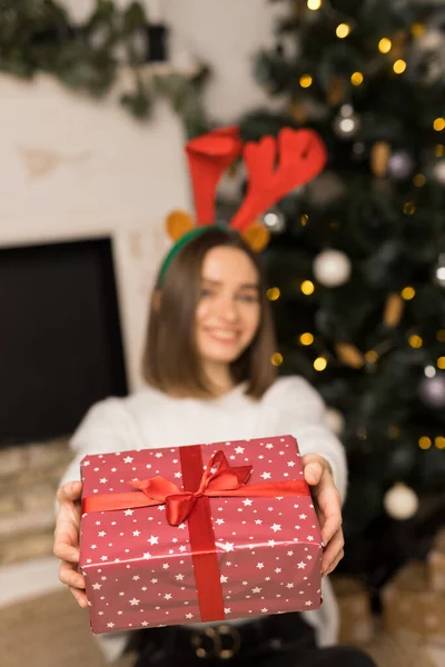 Mladá dívka dává červený vánoční dárek na kameru — Stock fotografie