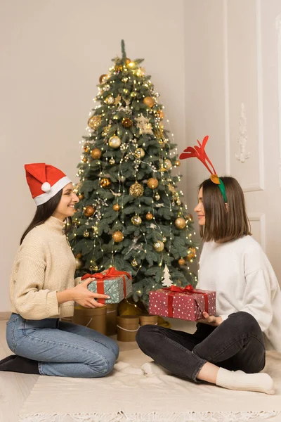 Dvě Krásné Dívky Bílých Svetrech Drží Červené Zelené Vánoční Dárky — Stock fotografie