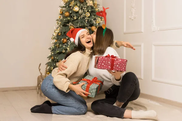Dvě Krásné Dívky Bílých Svetrech Objímají Drží Červené Zelené Vánoční — Stock fotografie