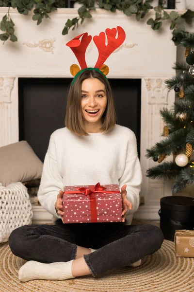 Молода дівчина з радістю отримає червоний різдвяний подарунок Стокова Картинка