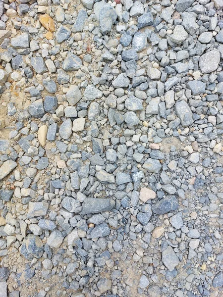 stones on road surface - gray material on sand