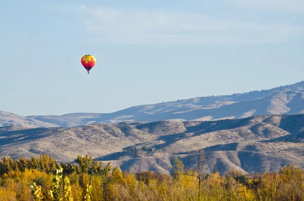 Hete luchtballon vliegen over de uitlopers Rechtenvrije Stockafbeeldingen