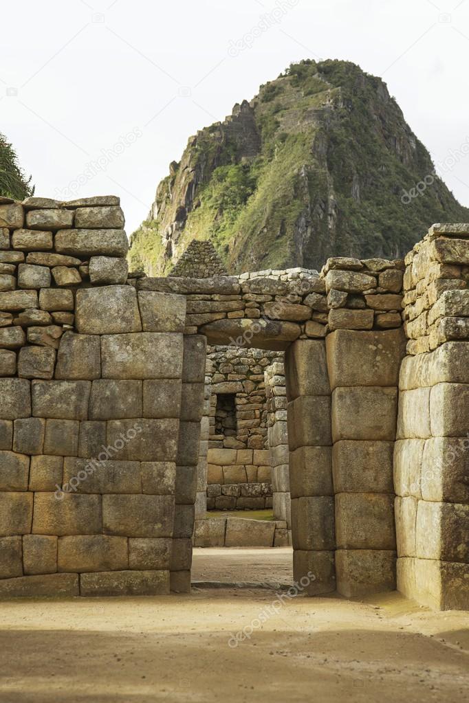 Wayna Picchu behind ruins of doors inside Machu Picchu, Peru
