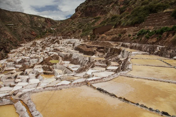 Pohled soli rybníků, maras, peru, Jižní Ameriky s cloudy modré obloze v pozadí — Stock fotografie