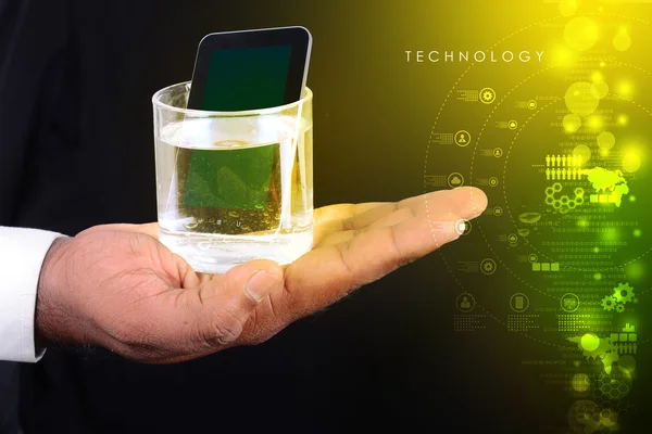 Glas vatten med tablett telefon — Stockfoto