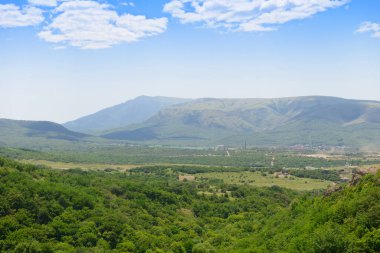 Dağların arasındaki yeşil vadiye yerleşin.
