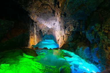 Yeraltı nehri, renkli lambalarla aydınlatılmış bir mağarada.