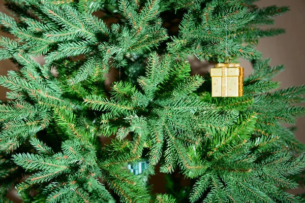 Ένα Παιχνίδι Χριστουγεννιάτικο Δέντρο Μορφή Ενός Χρυσού Κουτιού Κρέμεται Στα — Φωτογραφία Αρχείου