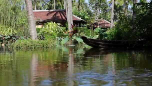 Одинокая лодка плавает в тропическом пруду — стоковое видео