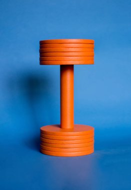 photo big orange dumbbell blue background