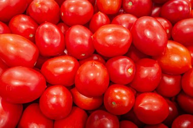 Marketteki taze erik domateslerinin sebze arka planı.