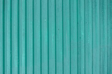 Eski, köhne metal kıvrımlı, turkuaz boyalı bir çitin soyut arka planı.