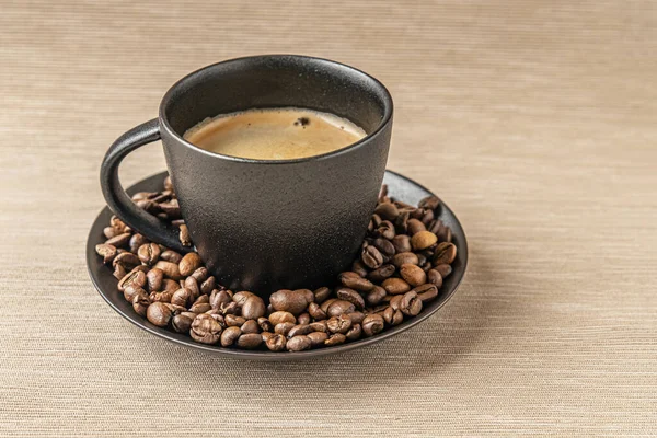 黒のセラミックカップとコーヒー豆の香り高い淹れたてのコーヒー — ストック写真