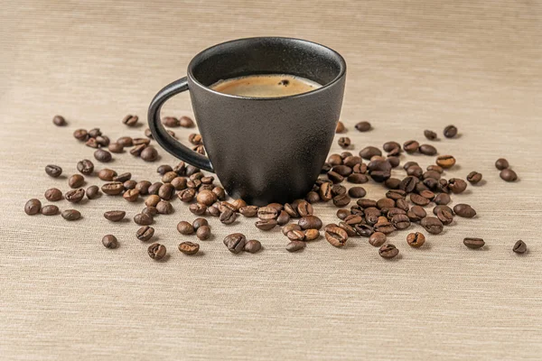 黒のセラミックカップとコーヒー豆の香り高い淹れたてのコーヒー — ストック写真