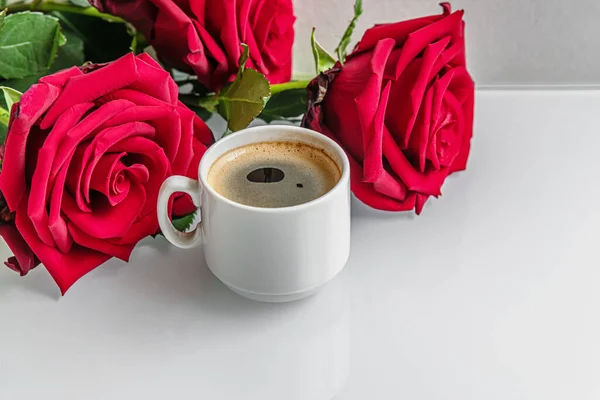Filiżankę Świeżej Kawy Arjmatycznej Czerwone Róże Białej Szklanej Powierzchni Bliska — Zdjęcie stockowe