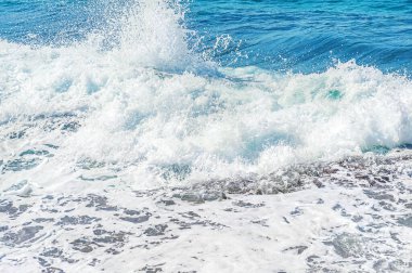 Açık rüzgarlı bir havada kayalık bir sahilde deniz sörfünün soyut arka planı