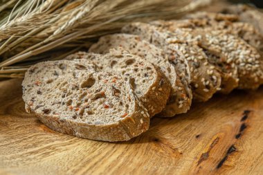 Havuç, keten, susam tohumu ve ahşap bir masa üzerinde buğday kulaklı ev yapımı dilimlenmiş topak diyet baget.