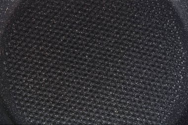 Kızartma tavasının yüzeyinin soyut arkaplanı ve yakın bir taş kaplama.