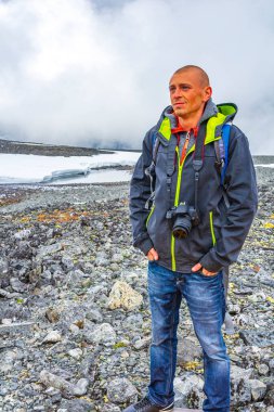 Yazın Jotunheimen 'de kar ile Galdhopiggen' de genç yürüyüşçü ve fotoğrafçı 2469 metre ile Norveç ve İskandinavya 'nın en büyük dağıdır..