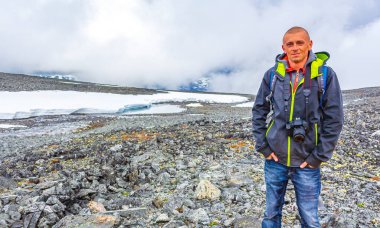 Yazın Jotunheimen 'de kar ile Galdhopiggen' de genç yürüyüşçü ve fotoğrafçı 2469 metre ile Norveç ve İskandinavya 'nın en büyük dağıdır..