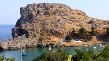 26. Rodos Yunanistan. Eylül 2018 St Pauls Bay Lindos plaj manzarası turkuaz berrak su botu turistleri ve Rodos Yunanistan güneşi ile.