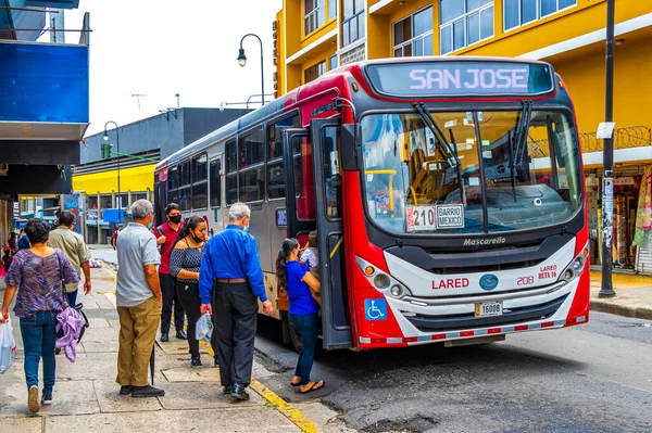 San Jose Kosta Rika 04. Ocak 2021 yoğun trafik ve şehir manzarasında San Jose Kosta Rika 'da insan ve araba dolu otobüsler.