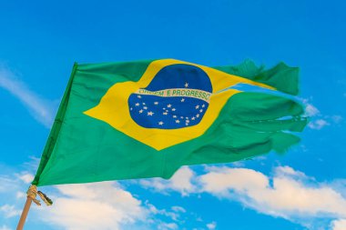Brezilya bayrağı rüzgarda dalgalanıyor Rio de Janeiro Brezilya 'nın arka planında mavi gökyüzü yeşil ve sarı renkleriyle.