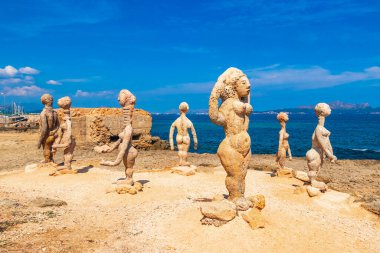 İspanya 'nın Balear Adası Mallorca' daki Can Picafort 'ta, engebeli doğal kıyı ve sahil manzarasında taş heykeller, turkuaz su dalgaları, dağlar, kayalar ve taşlar..