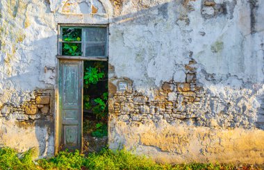 Yunanistan 'ın Rodos kentindeki eski yıkılmış ve kirli evler ve binalar bir kapı ve pencerenin dokusu.