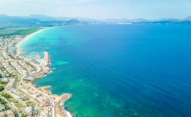 Doğal kıyı ve sahil manzaralı insansız hava aracı Alcudia Körfezi 'nden gelen turkuaz su dalgaları ve ormanlık alanlarla İspanya' nın Balearic Adası Mallorca 'daki Can Picafort' ta bulunan Playa del Muro.