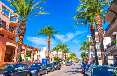 Mallorca İspanya 14. Eylül 2018 Palmiye ağaçlı tipik sokak yolu İspanya 'nın Balear Adası Mallorca' daki Can Picafort 'ta insanları ve turistleri binalar..
