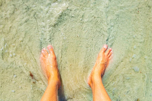 Feet in the water and sand of the tropical mexican beach of Playa 88 and Punta Esmeralda in Playa del Carmen Mexico.