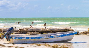 Holbox Meksika 21. Aralık 2021 'de Panorama manzarası güzel Holbox adası sahilinde eski mavi bir tekne ve Quintana Roo Mexico' da turkuaz bir su dalgaları vardı..