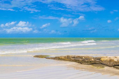 Panorama landscape view on beautiful Holbox island sandbank and beach with waves turquoise water boulders rocks and stones in Quintana Roo Mexico.